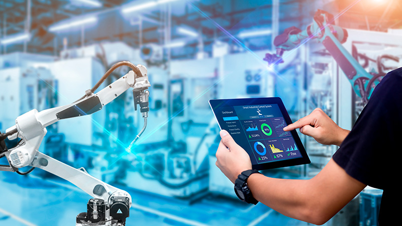 Engineer Hands holding tablet on blurred robot arm automation mac